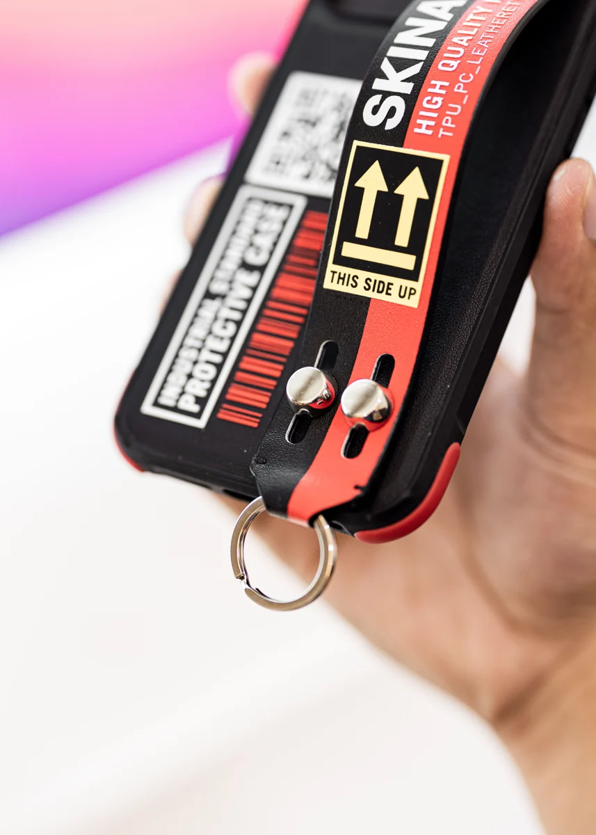 Protective phone case with a strap, held in a hand